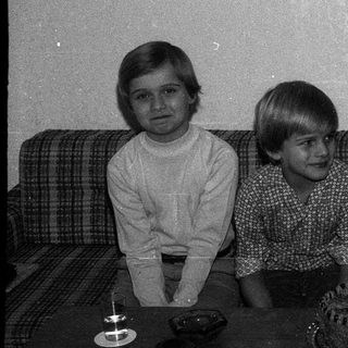 Family celebrating birthday with lit candles on cake.