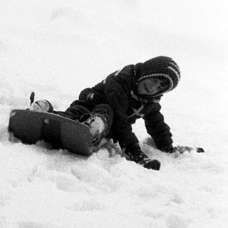 Person skiing in snow-covered forest, taking a break.