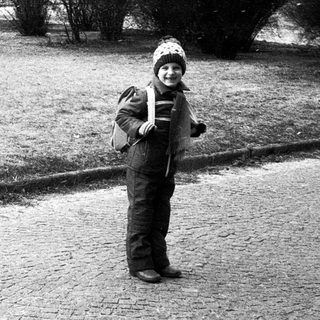 Child holding snowball in winter park.