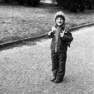 Child smiling outdoors in winter attire.