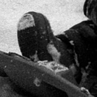 Child sledding down snow-covered hill.