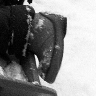 Child joyfully sledding down snow-covered slope.