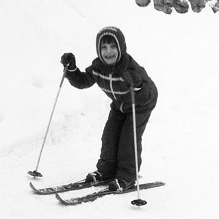 Child skiing on snow-covered slope.
