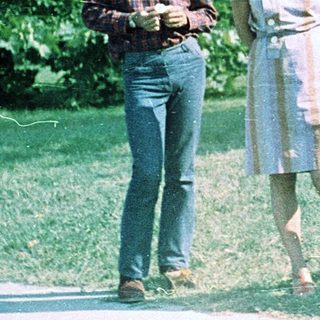 Three people posing outdoors in a park setting.
