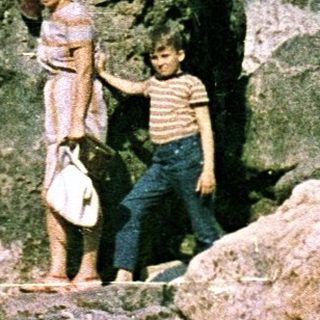 Four people posing on rocky seaside cliffs.