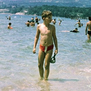 Shallow beach scene with children playing in warm water.