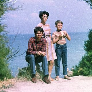 Family posing near coastal cliffside path.