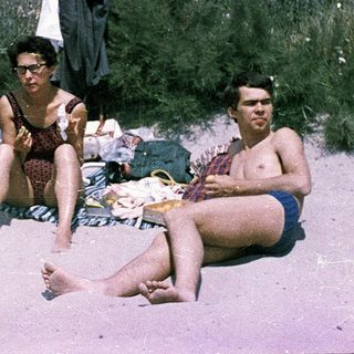 Family beach outing in vintage swimwear.
