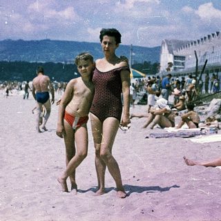 Busy beach scene from mid-20th century.