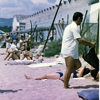 Busy beach scene from mid-20th century.