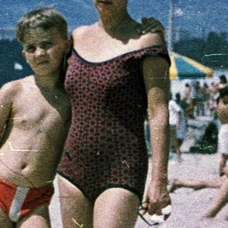 Busy beach scene from mid-20th century.