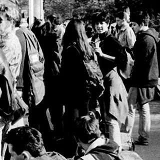 People waiting for bus with luggage.