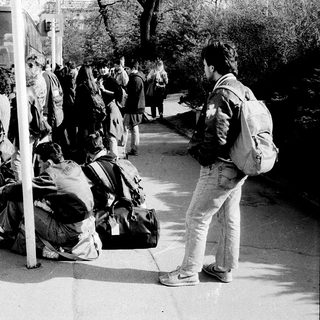 People waiting for bus with luggage.
