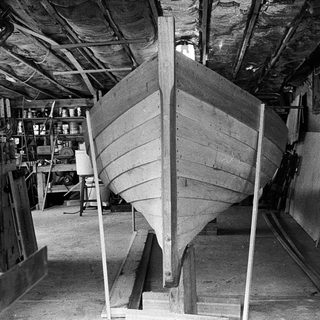 Boat hull under construction in workshop.