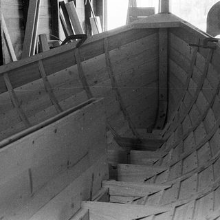 Ship hull under construction with wooden framing.