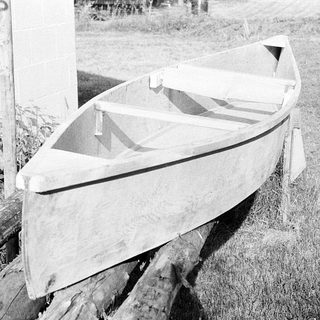 Vintage wooden boat resting on grass.