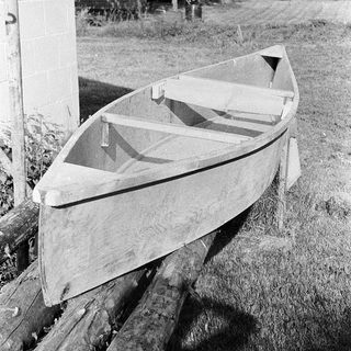 Vintage wooden canoe resting on supports.