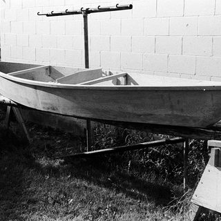 Traditional wooden boat on land support.