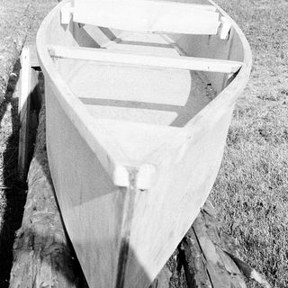 Traditional wooden canoe on dry land.