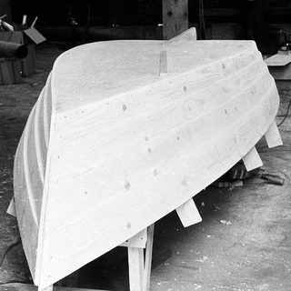 Molded boat hull in workshop setting.