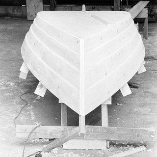 Boat hull under construction in workshop.