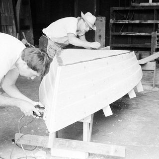 Two men working on boat construction.