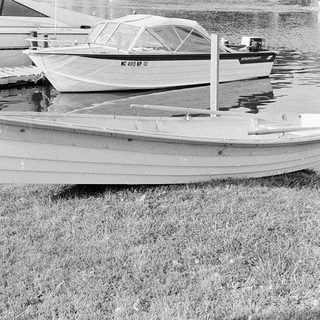 Small boats docked on grass near water.
