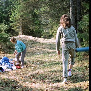 People setting up camping gear in forested area.