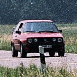 Three cyclists riding along a rural road.