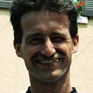Man smiling outside a residential building.