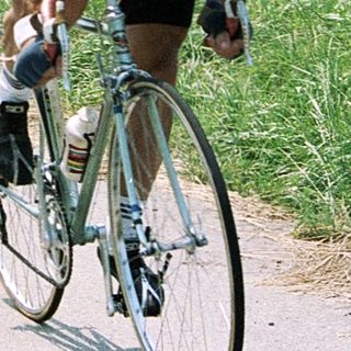Two cyclists racing on a rural road.