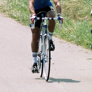 Two cyclists racing on a rural road.