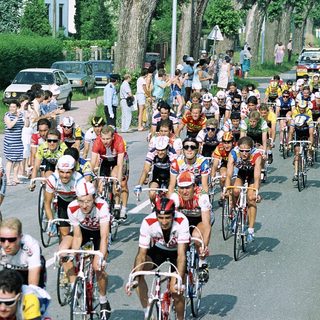 Crowded road cycling race with spectators.