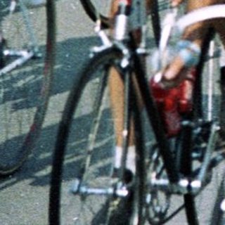 Cyclists racing in a group on a road.