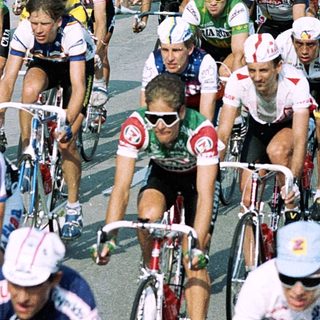 Cyclists racing in a group on a road.