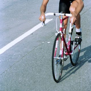 Professional cyclist racing on road bike.