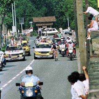 Motorcade with police escort on city road.