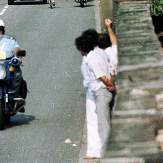 Motorcade with police escort on city road.