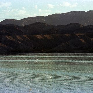 Mountain range reflected in calm lake water.
