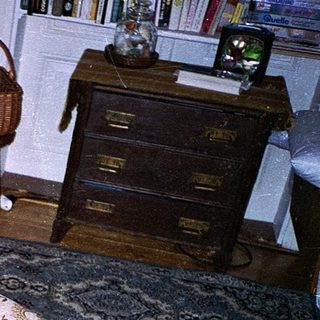 Teen holding game controller, lounging drowsily in armchair.