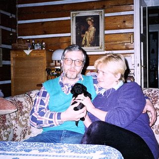 Two people holding a microphone indoors.