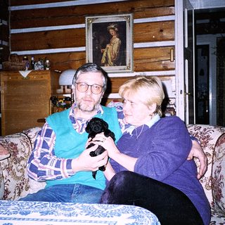 Two people holding a microphone indoors.