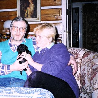 Two people holding a microphone indoors.