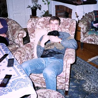Two people relaxing indoors with old-fashioned furniture.