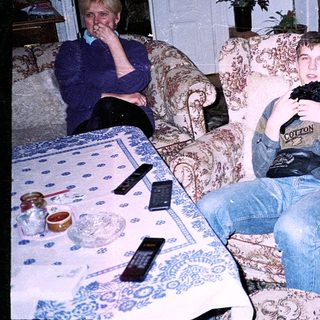 Two people relaxing indoors with old-fashioned furniture.