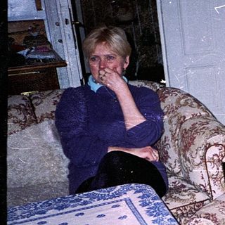 Two people relaxing indoors with old-fashioned furniture.