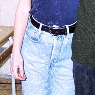 Two people posing indoors in casual 1990s attire.