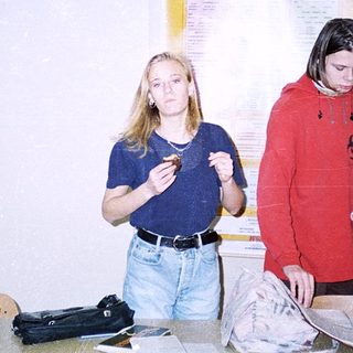 Three people examining a map indoors.