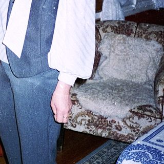 Woman in vintage-style vest and pants indoors.