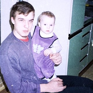 A man holds a young child indoors.